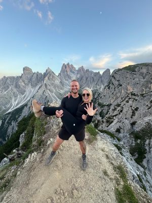 Eric lifts Hunter in joy after proposing in the Dolomites, celebrating their mountaintop moment with a stunning Mark’s Diamonds engagement ring.